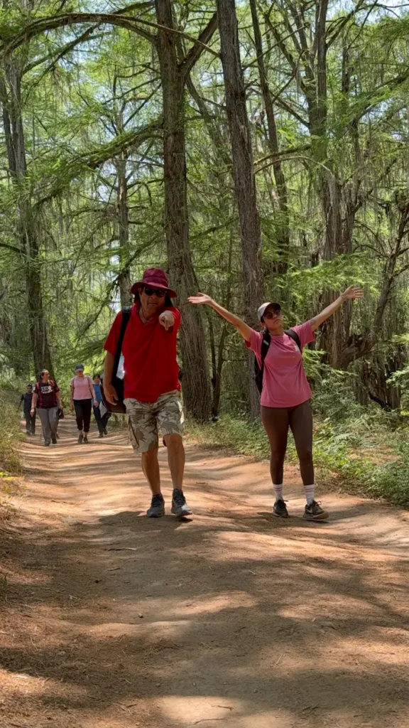 Caminata San Quintin, un chico y una chica caminando entre árboles